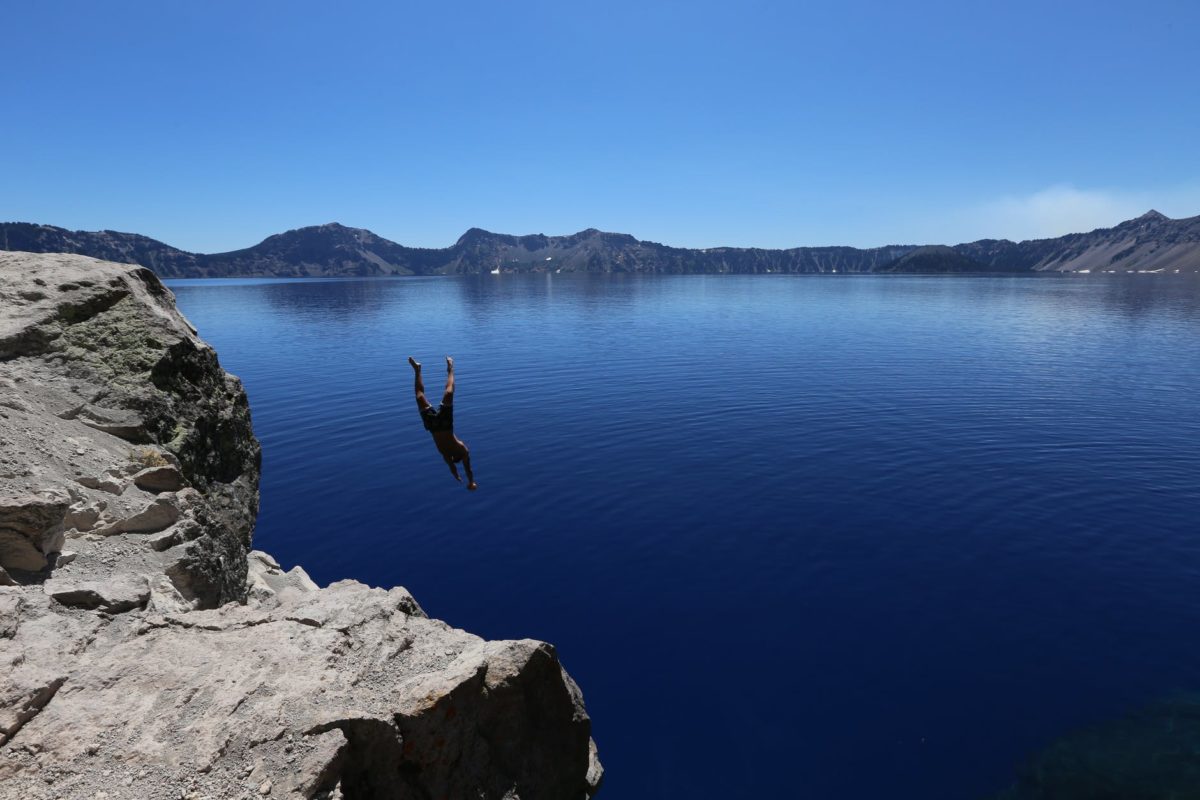 photo of man diving in to water